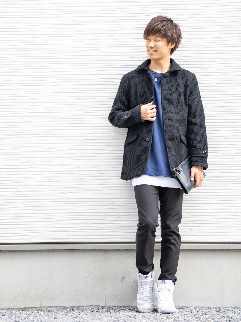 ブラック系のピーコート、ブルー系のTシャツ/カットソー、ブルー系のクラッチバッグを着用したメンズの秋コーディネートの1枚目の写真