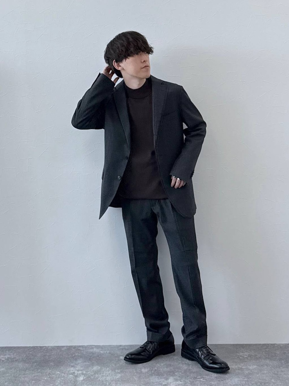 グレー系のテーラードジャケット、グレー系のスラックス、ブラウン系のニット/セーターを着用したメンズの秋コーディネートの1枚目の写真