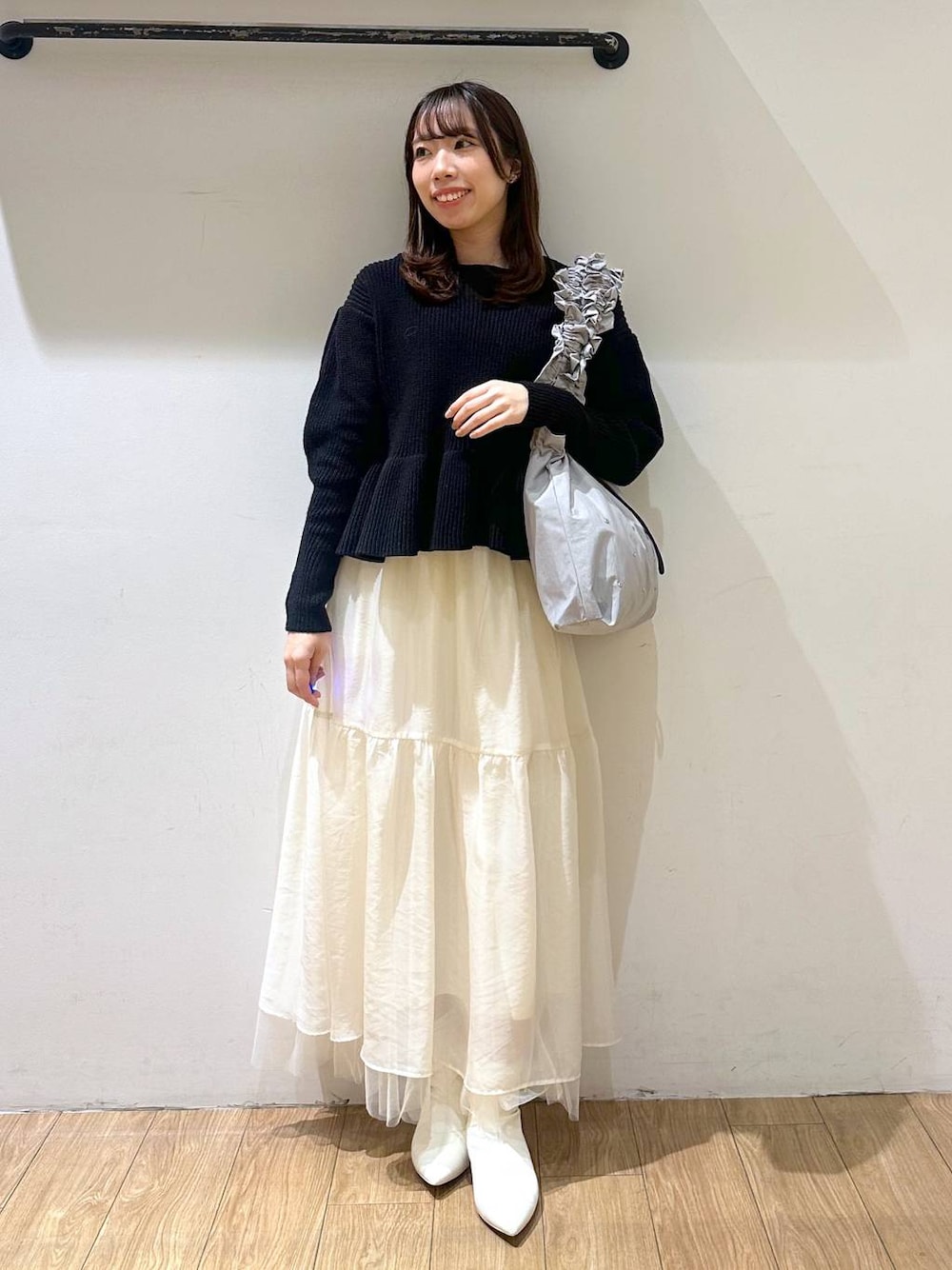 ホワイト系のブーツ、ホワイト系のスカート、グレー系のトートバッグを着用したレディースの冬コーディネートの1枚目の写真
