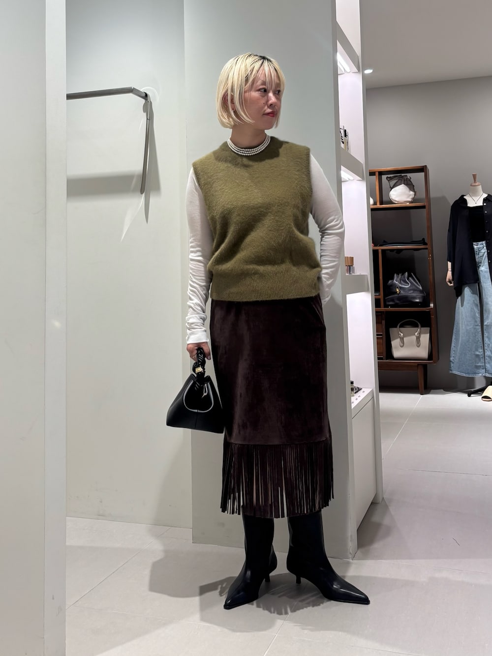 ホワイト系のTシャツ/カットソー、グリーン系のベスト、ブラック系のブーツを着用したレディースの夏コーディネートの1枚目の写真