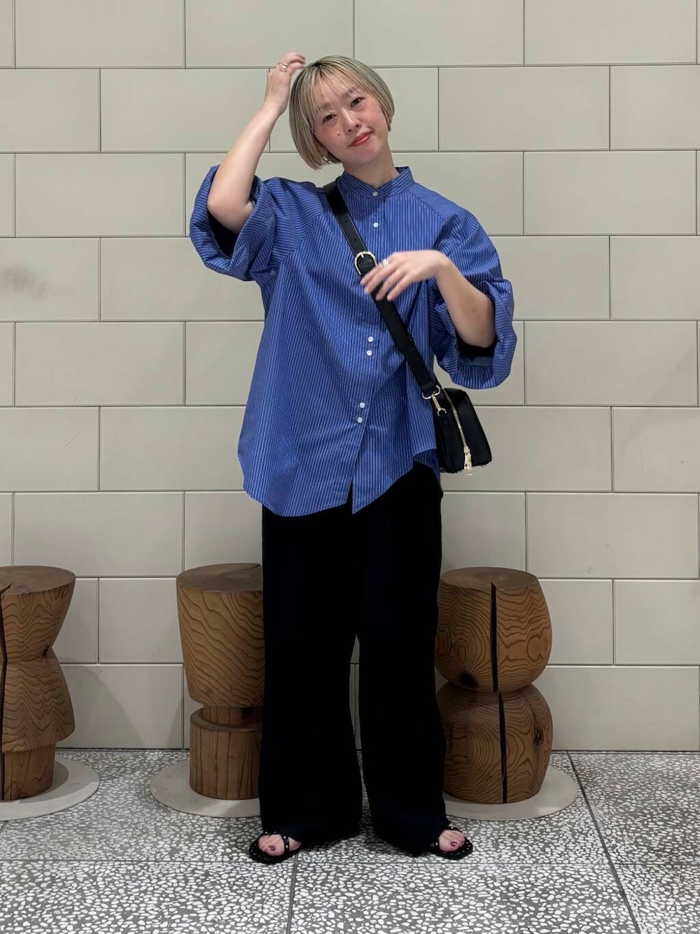 ブラック系のその他パンツ、ブラック系のショルダーバッグ、ブルー系のシャツ/ブラウスを着用したレディースの春コーディネートの1枚目の写真
