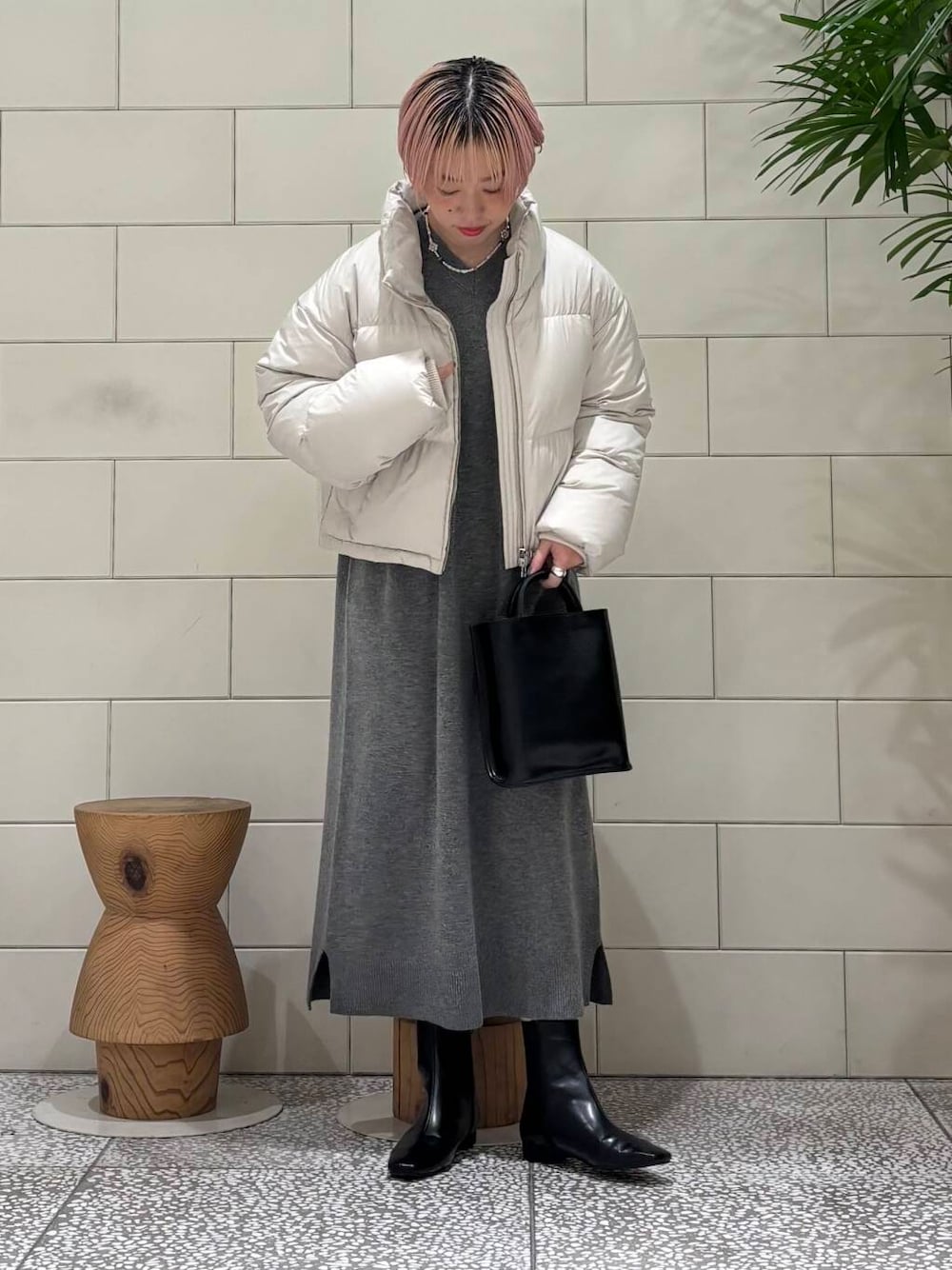 ブラック系のトートバッグ、ブラック系のブーツ、ホワイト系のダウンジャケット/コートを着用したレディースの冬コーディネートの1枚目の写真