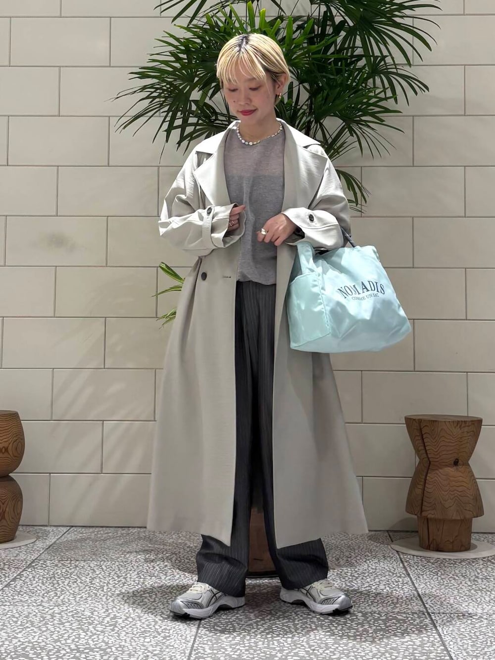 グレー系のその他パンツ、グリーン系のトレンチコート、グレー系のニット/セーターを着用したレディースの冬コーディネートの1枚目の写真