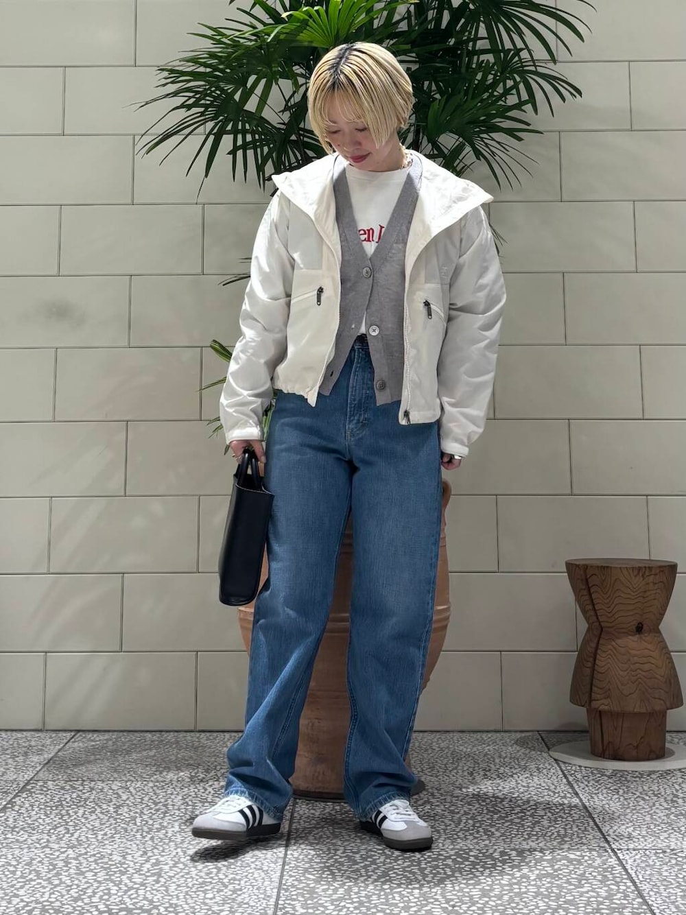 グレー系のカーディガン/ボレロ、ホワイト系のスニーカー、その他のTシャツ/カットソーを着用したレディースの冬コーディネートの1枚目の写真