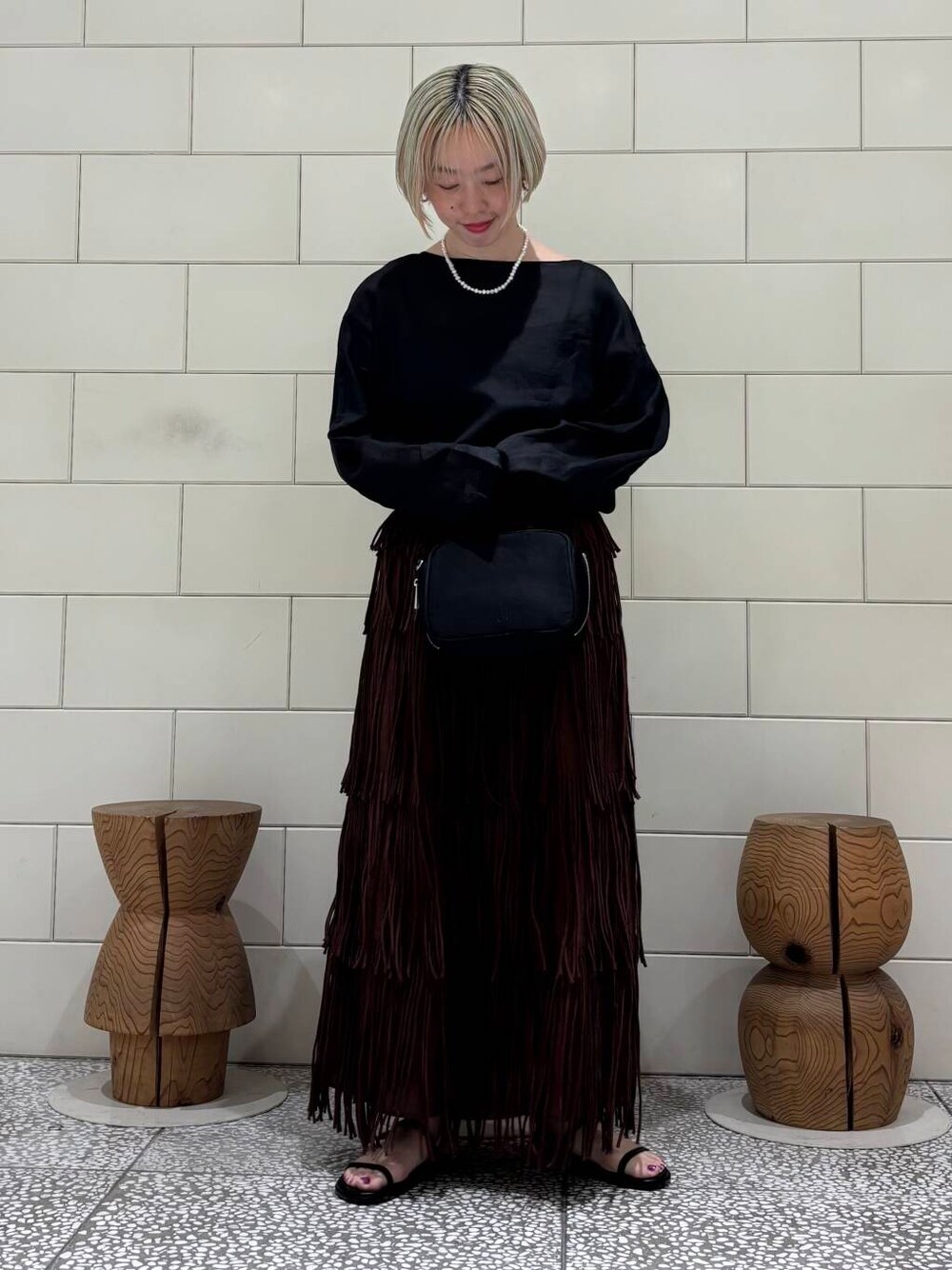 ブラック系のシャツ/ブラウス、ブラック系のボストンバッグ、ブラウン系のスカートを着用したレディースの春コーディネートの1枚目の写真