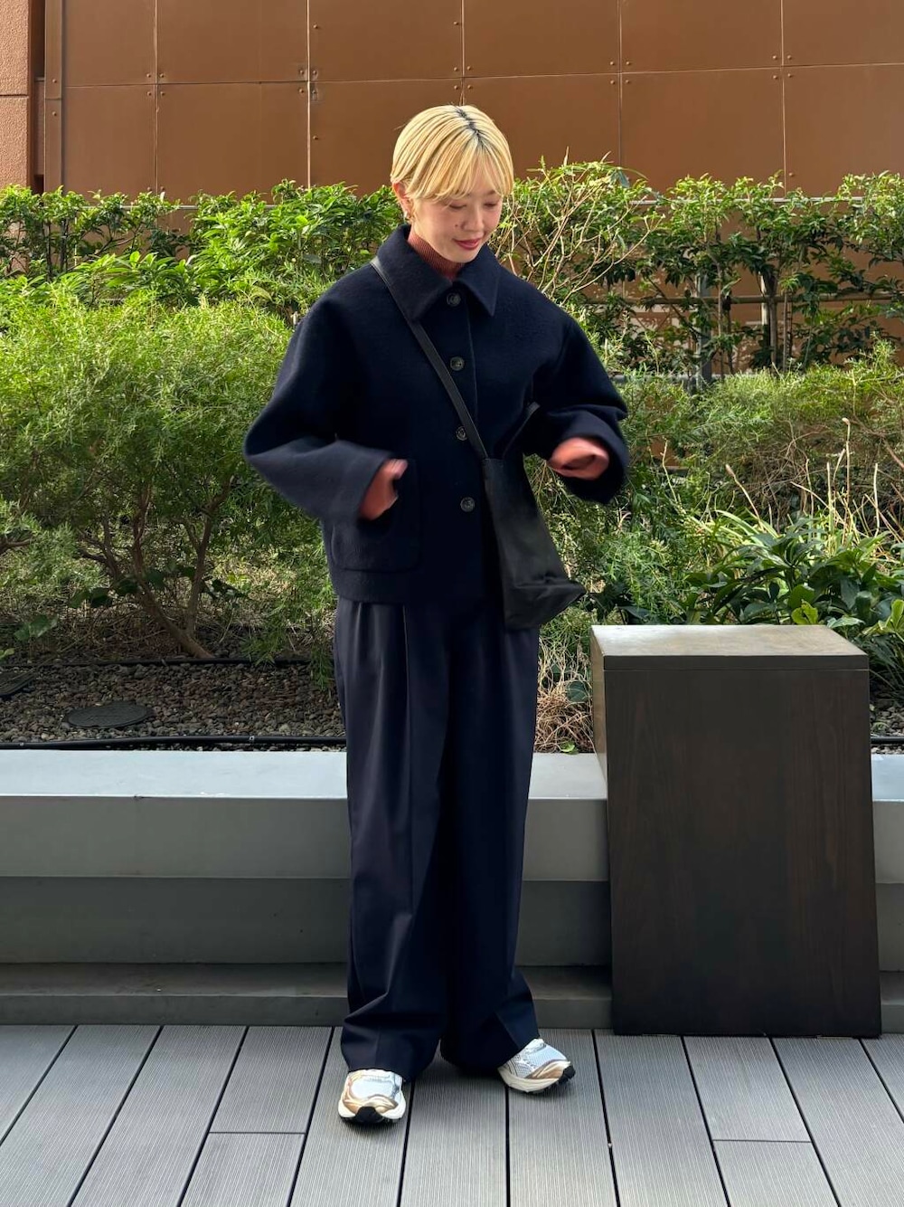 ホワイト系のスニーカー、オレンジ系のニット/セーター、ブルー系のその他パンツを着用したレディースの秋コーディネートの1枚目の写真