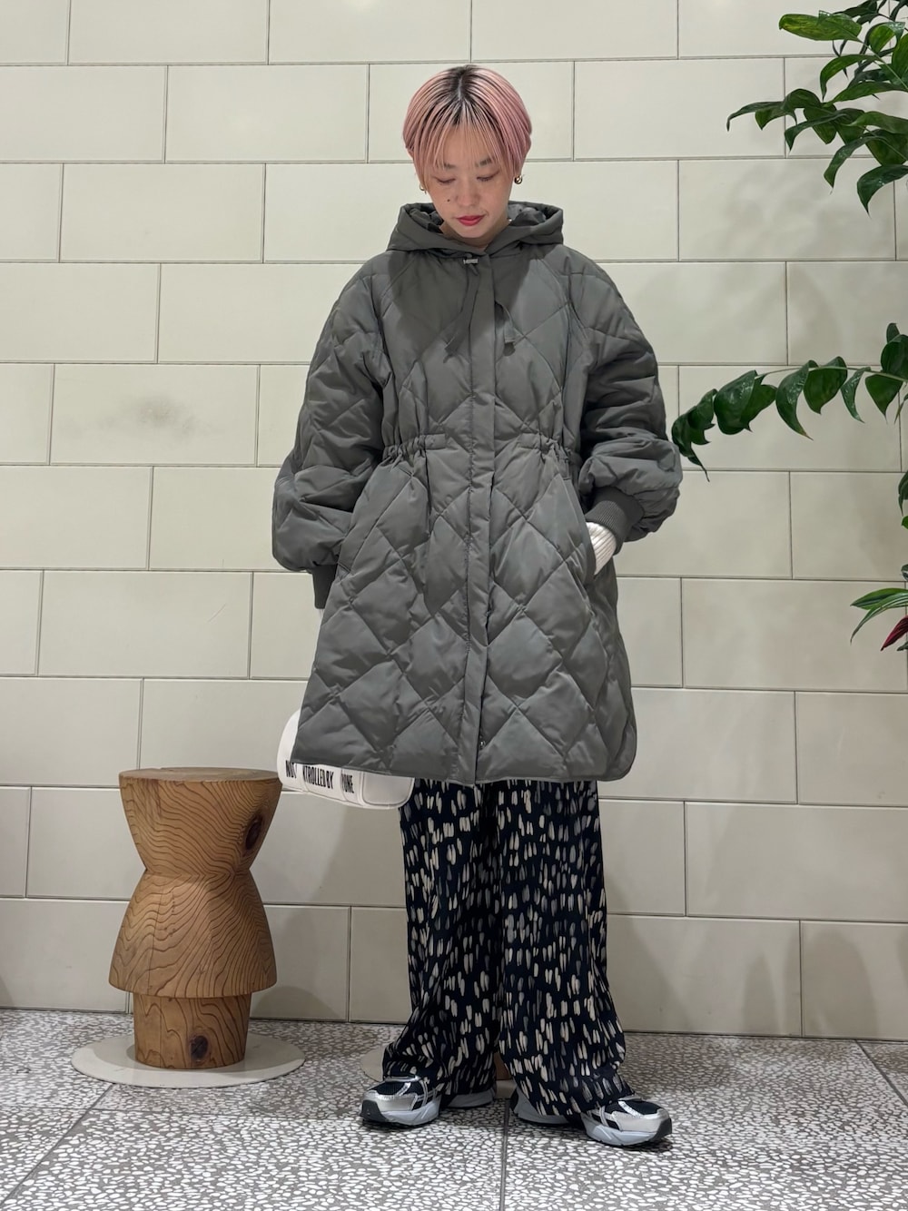 グレー系のダウンジャケット/コート、ベージュ系のニット/セーター、ブラック系のその他パンツを着用したレディースの冬コーディネートの1枚目の写真