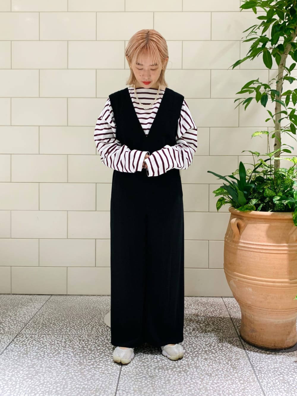 レッド系のTシャツ/カットソー、ブラック系のサロペット/オーバーオール、ホワイト系のスニーカーを着用したレディースの夏コーディネートの1枚目の写真