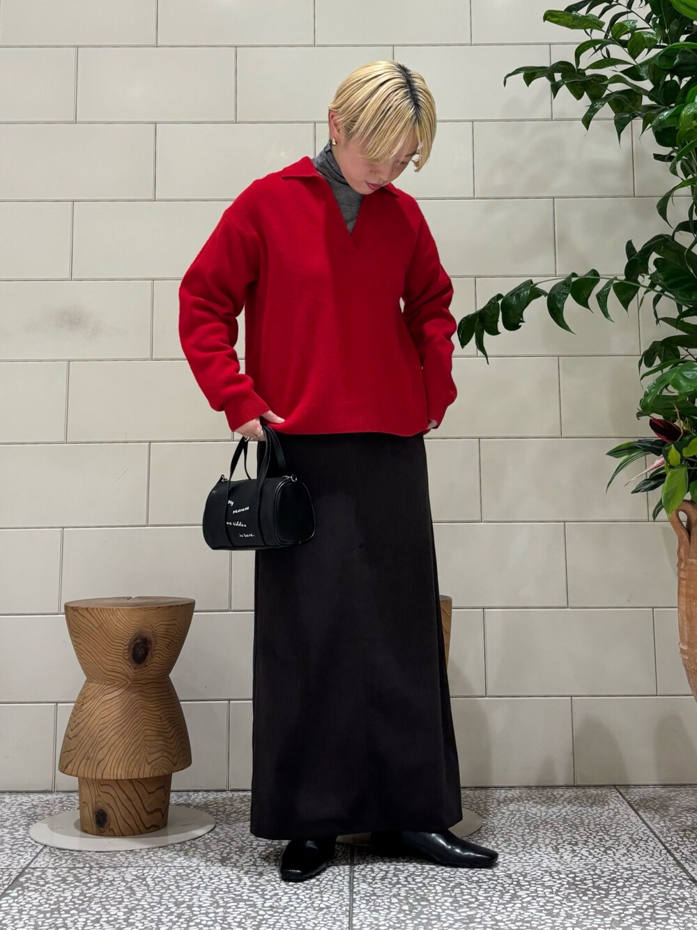 ブラック系のTシャツ/カットソー、ブラック系のブーツ、ブラック系のボストンバッグを着用したレディースの秋コーディネートの1枚目の写真