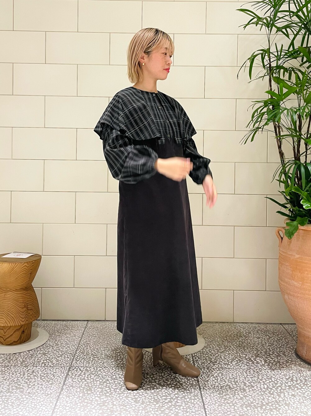 グレー系のワンピース、ブラック系のシャツ/ブラウス、ベージュ系のブーツを着用したレディースの冬コーディネートの1枚目の写真