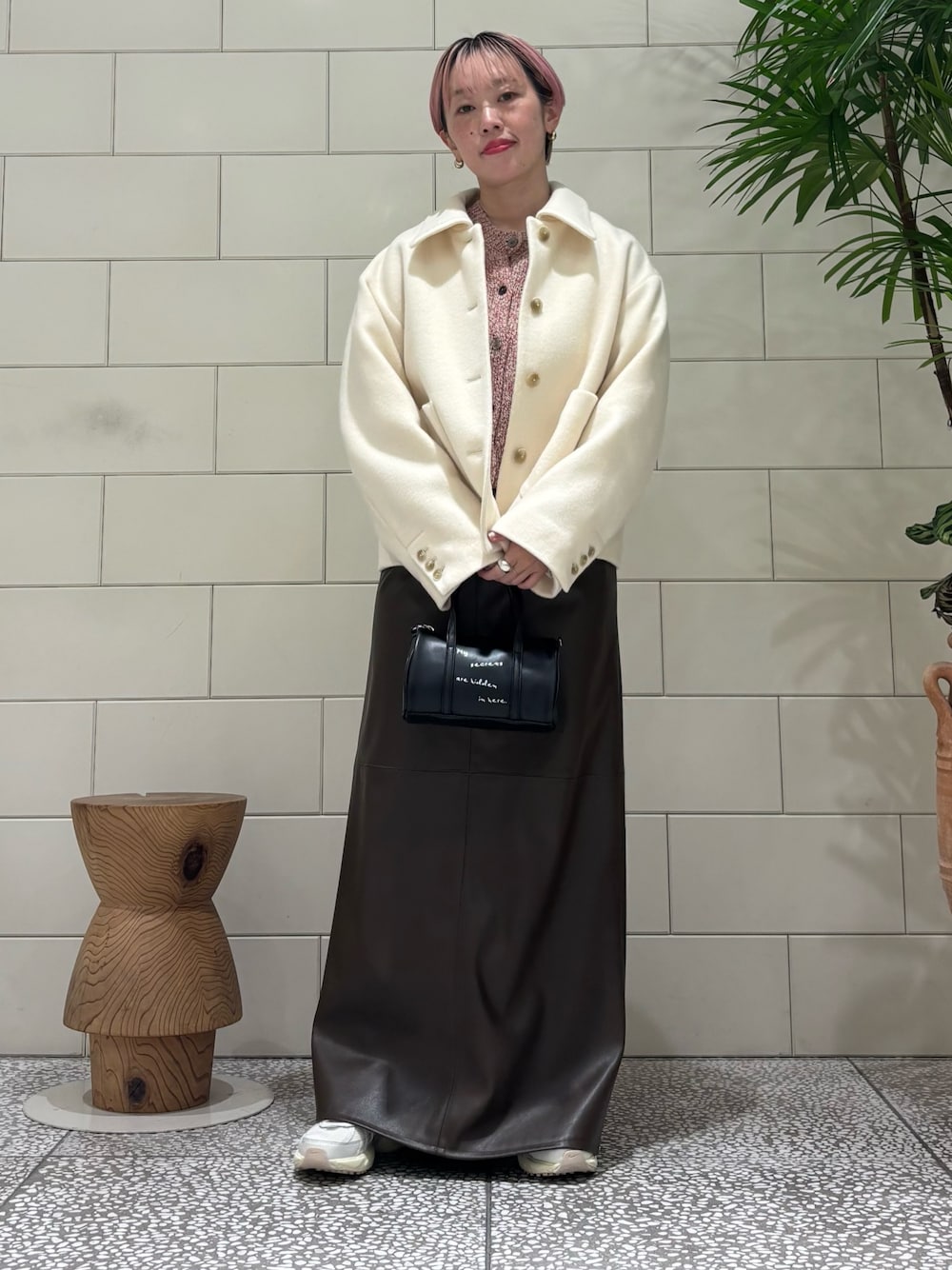 ホワイト系のその他アウター、ベージュ系のカーディガン/ボレロ、ブラウン系のスカートを着用したレディースの冬コーディネートの1枚目の写真