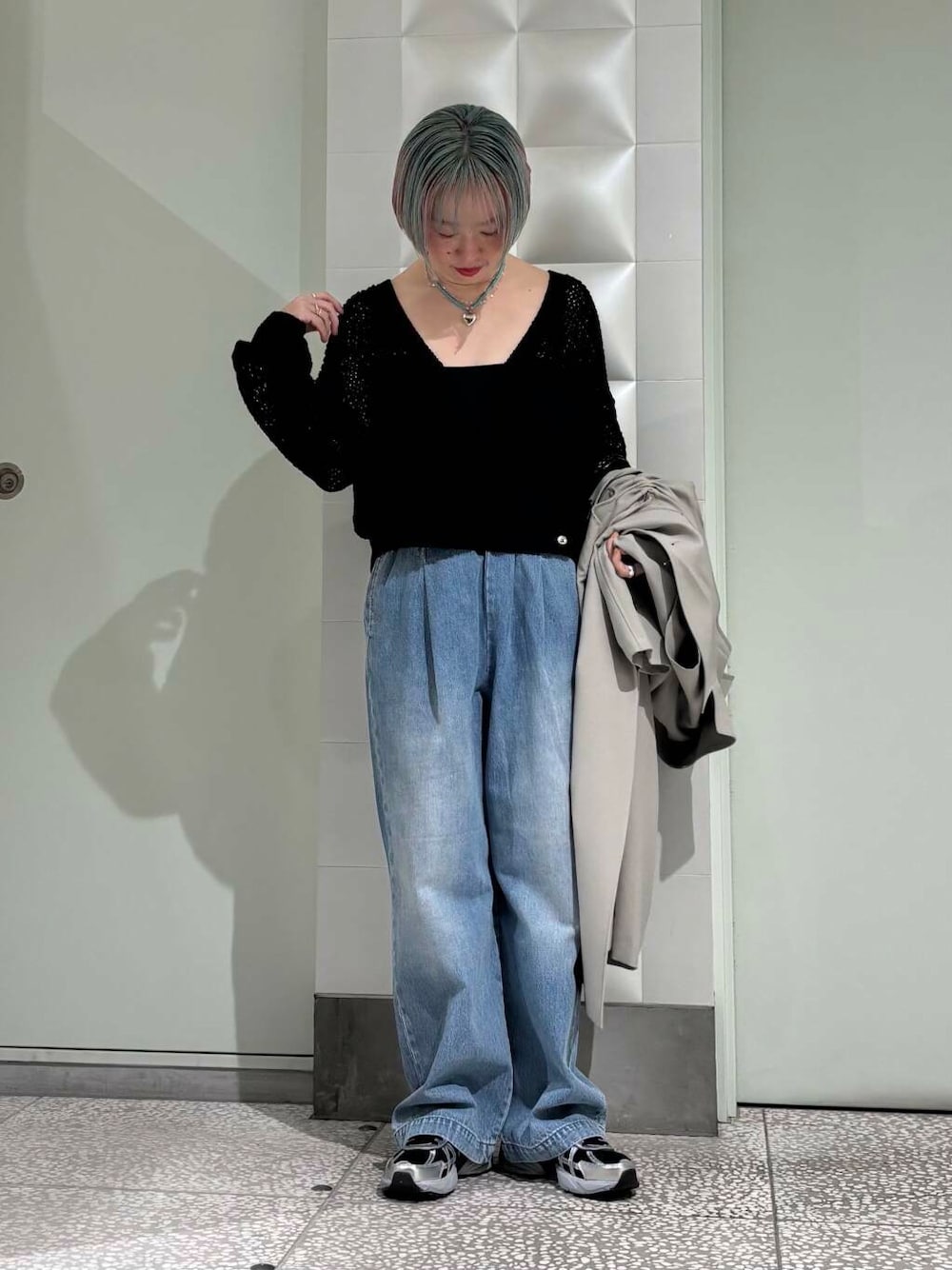 ブルー系のデニムパンツ、グリーン系のトレンチコート、ブラック系のスニーカーを着用したレディースの春コーディネートの1枚目の写真