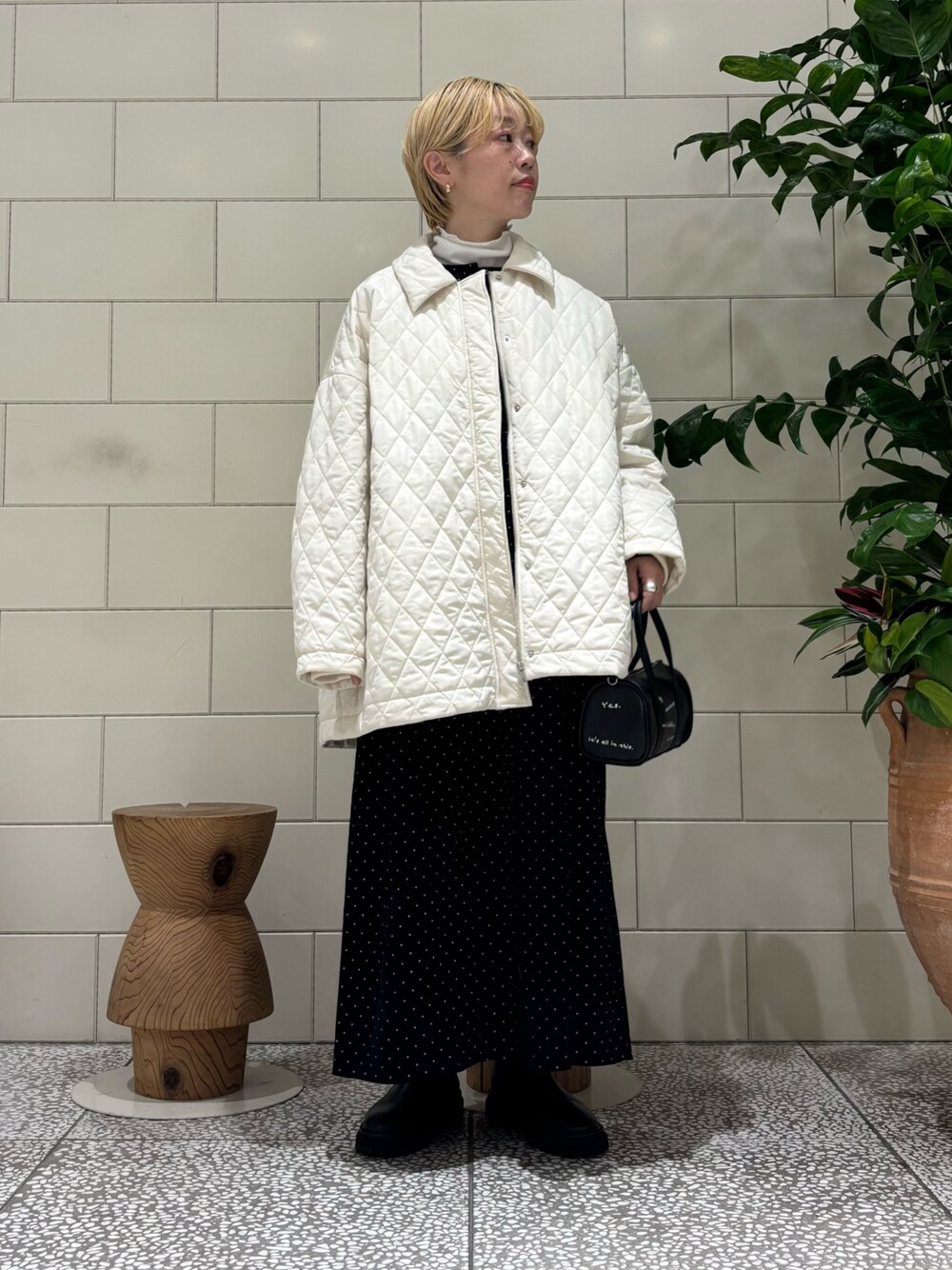 ブラック系のボストンバッグ、ブラック系のワンピース、ホワイト系のダウンジャケット/コートを着用したレディースの秋コーディネートの1枚目の写真