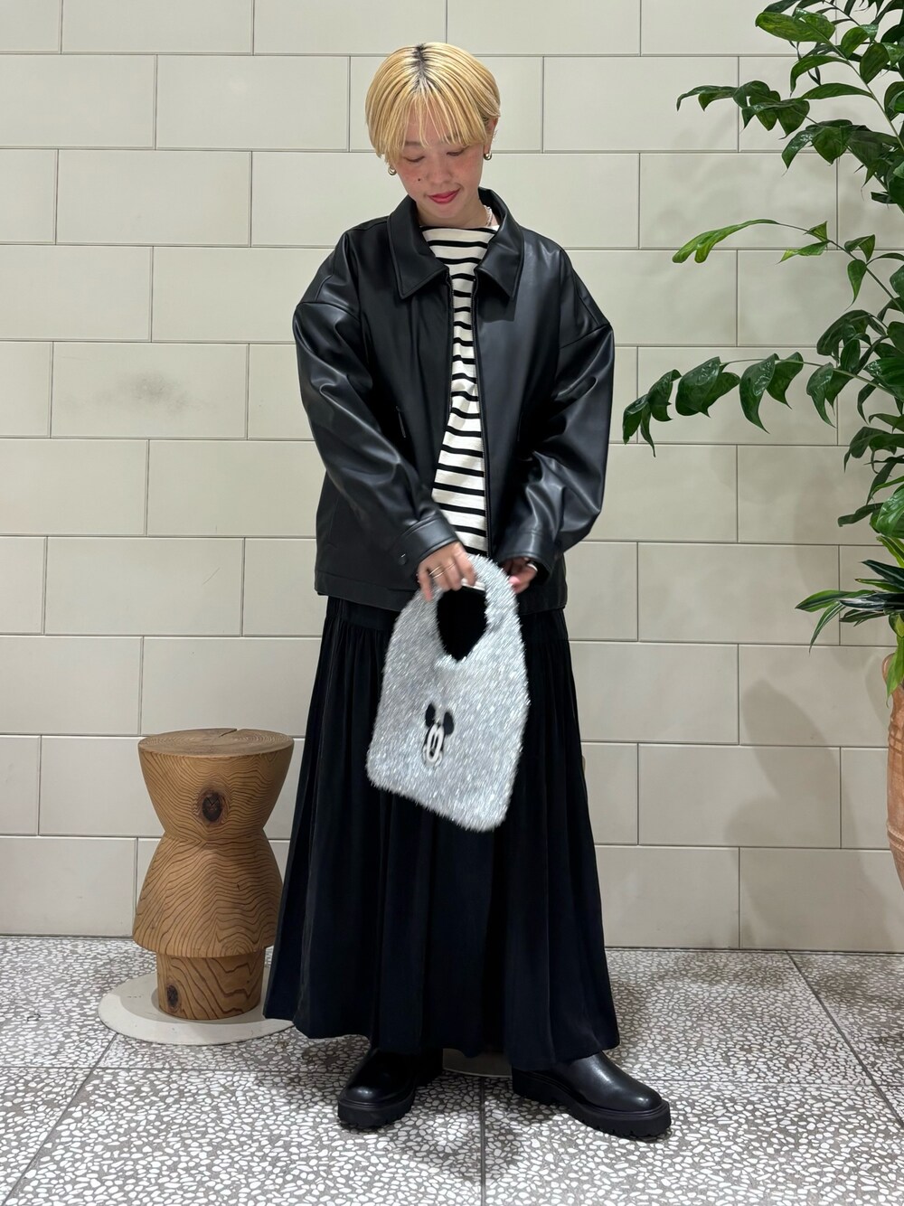 ブラック系のブルゾン、ホワイト系のTシャツ/カットソー、ブラック系のスカートを着用したレディースの秋コーディネートの1枚目の写真