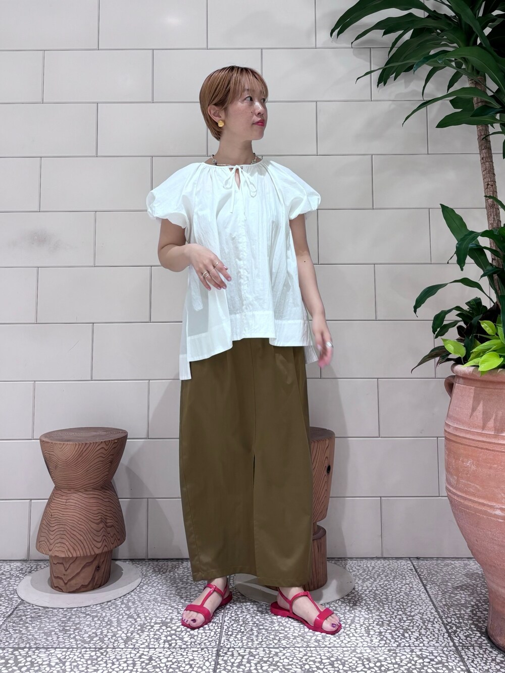 ホワイト系のシャツ/ブラウス、ブラウン系のスカートを着用したレディースの春コーディネートの1枚目の写真