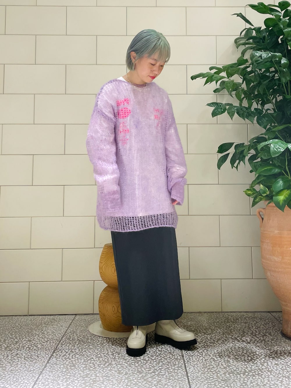 パープル系のニット/セーター、ホワイト系のTシャツ/カットソー、グレー系のスカートを着用したレディースの秋コーディネートの1枚目の写真