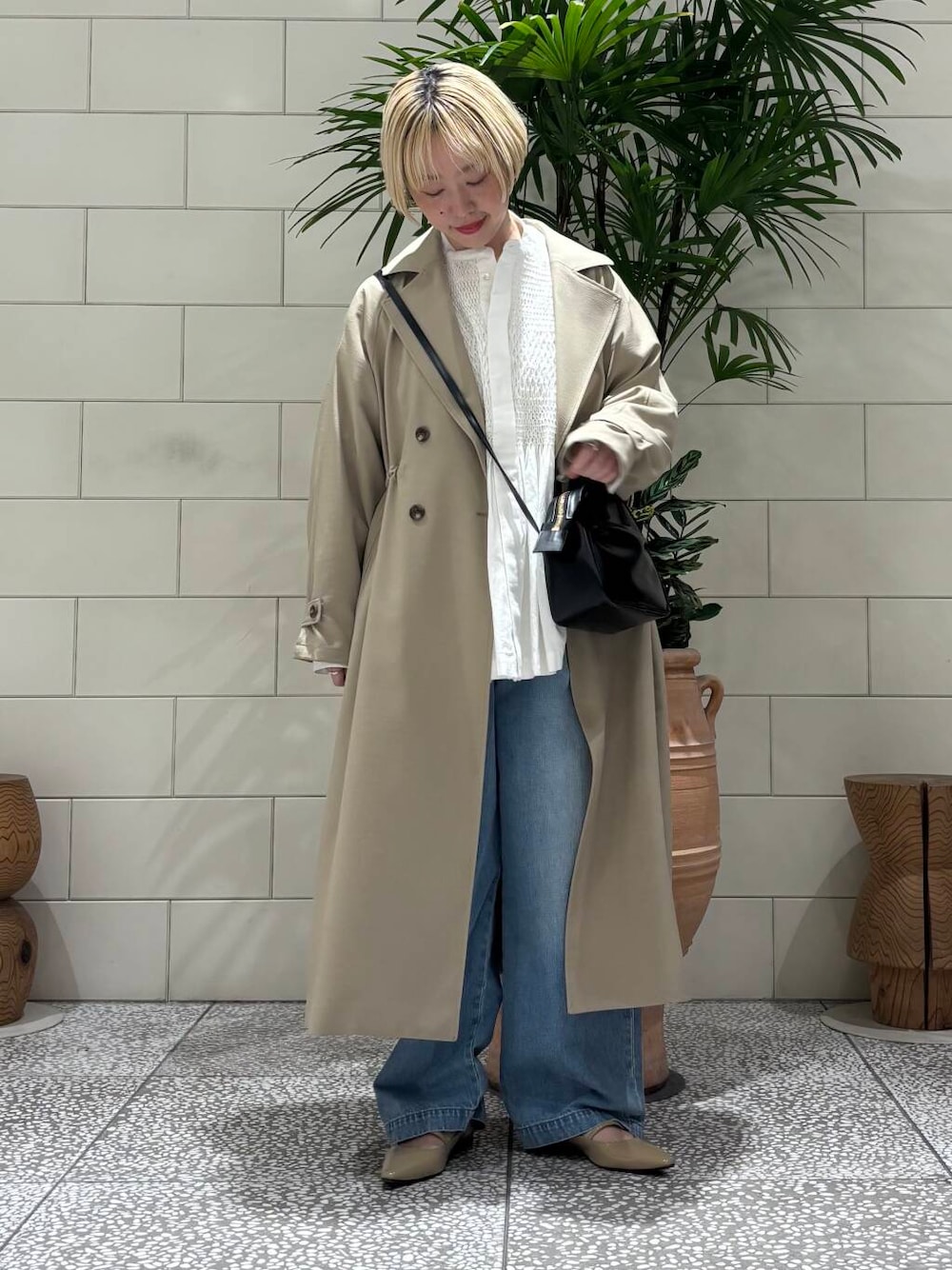 ブルー系のデニムパンツ、ベージュ系のトレンチコート、ホワイト系のシャツ/ブラウスを着用したレディースの冬コーディネートの1枚目の写真