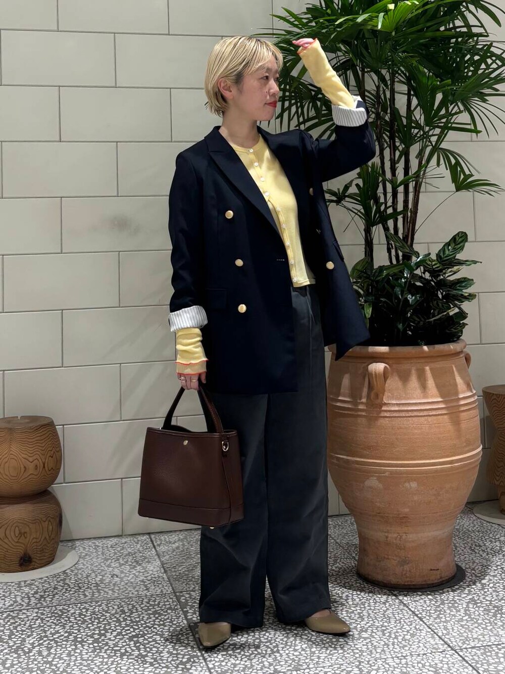 ブルー系のその他アウター、グレー系のその他パンツ、ブラウン系のハンドバッグを着用したレディースの冬コーディネートの1枚目の写真