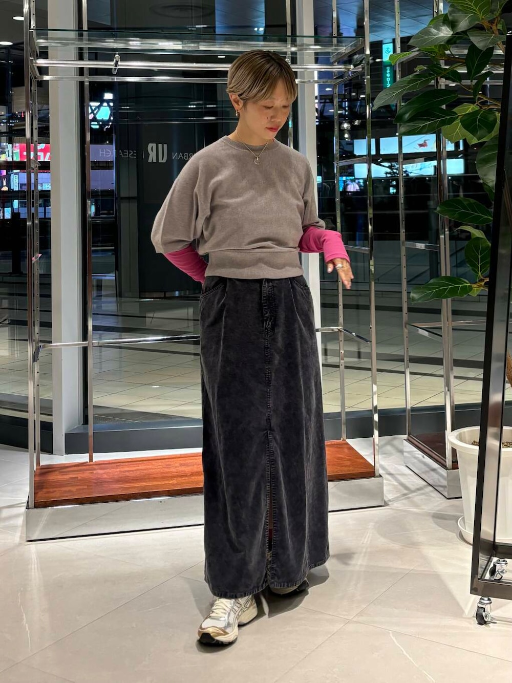 ピンク系のTシャツ/カットソー、ホワイト系のスニーカー、ブルー系のスカートを着用したレディースの秋コーディネートの1枚目の写真