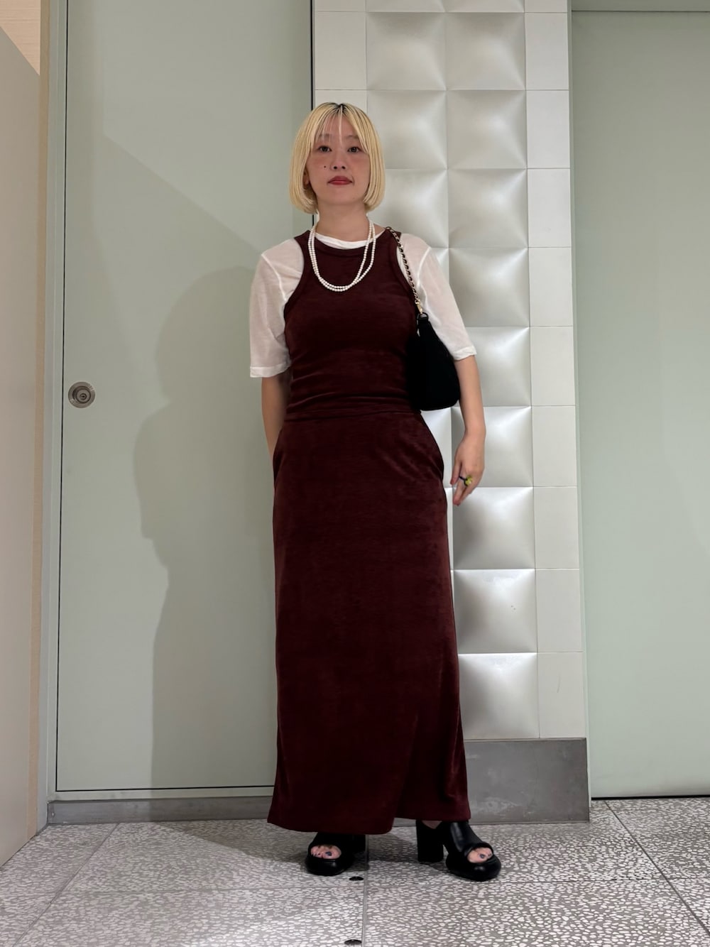 ホワイト系のTシャツ/カットソー、ブラック系のハンドバッグ、ブラウン系のスカートを着用したレディースの夏コーディネートの1枚目の写真