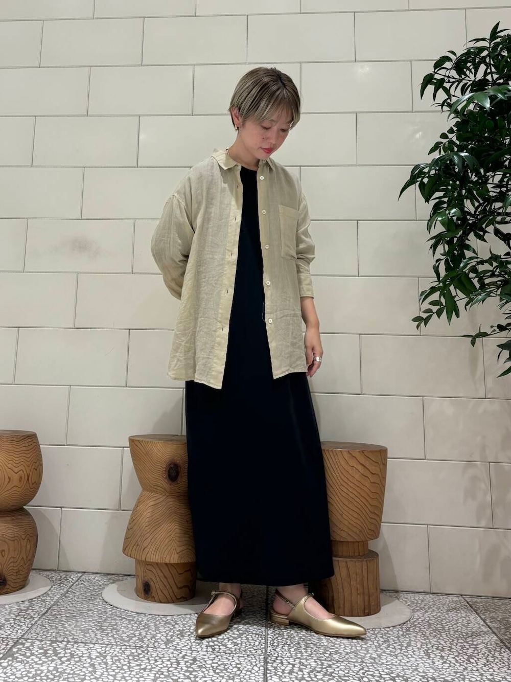 ゴールド系のパンプス、ブラック系のワンピース、ベージュ系のTシャツ/カットソーを着用したレディースの夏コーディネートの1枚目の写真