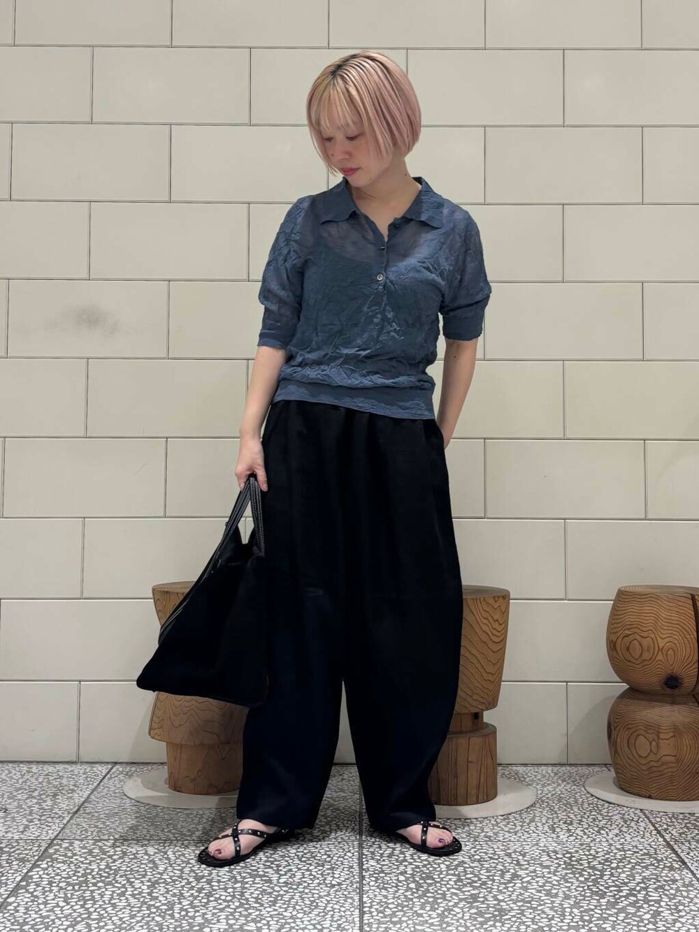 グレー系のニット/セーター、ブラック系のサンダルを着用したレディースの春コーディネートの1枚目の写真