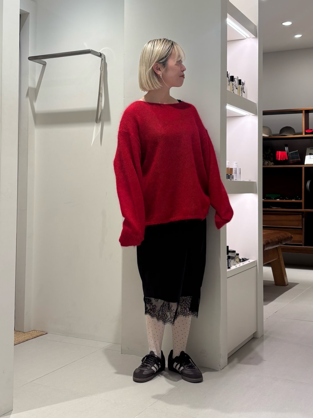 レッド系のニット/セーター、ブラウン系のスニーカー、ホワイト系のその他アンダーウェア/インナーを着用したレディースの秋コーディネートの1枚目の写真