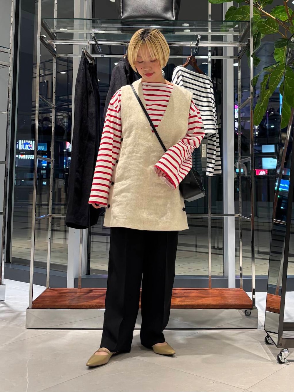 ブラック系のその他パンツ、レッド系のTシャツ/カットソー、ベージュ系のベストを着用したレディースの春コーディネートの1枚目の写真