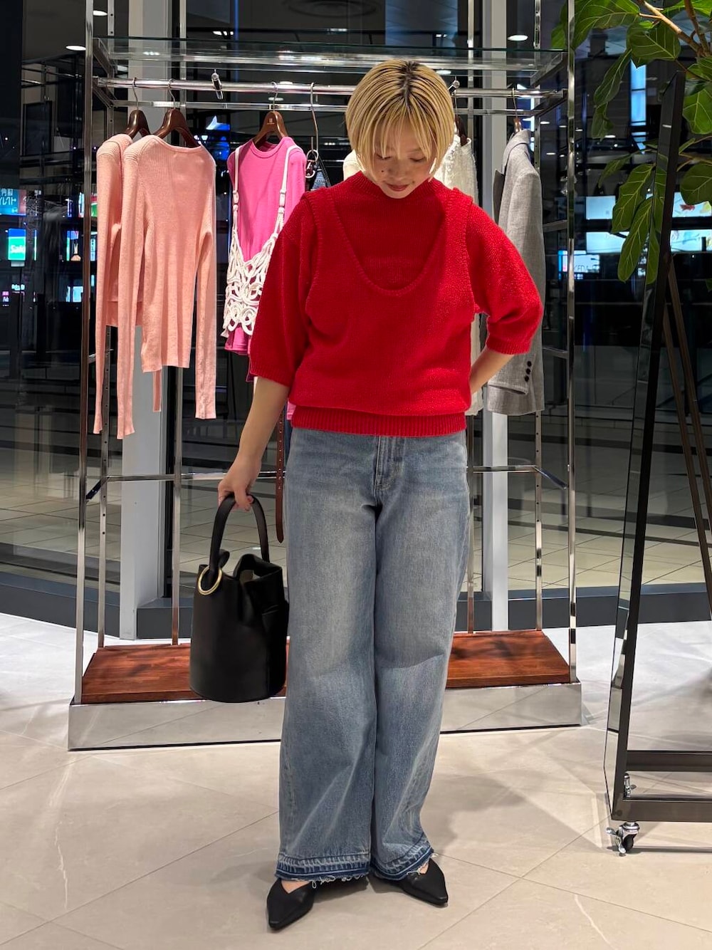 ブルー系のデニムパンツ、レッド系のベスト、レッド系のニット/セーターを着用したレディースの冬コーディネートの1枚目の写真