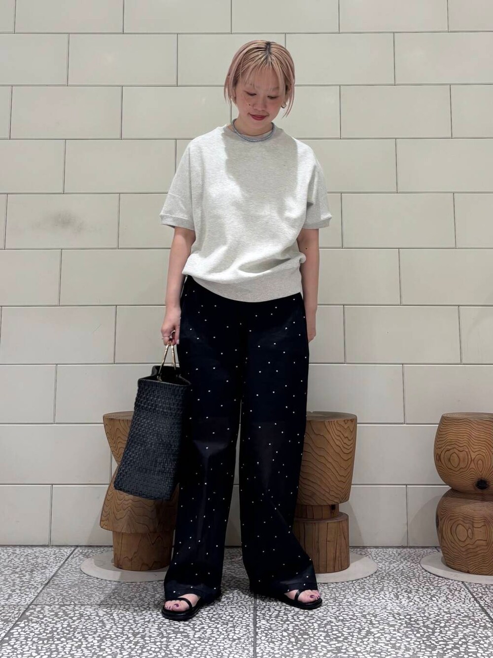 ブラック系のその他パンツ、ブラック系のサンダル、グレー系のTシャツ/カットソーを着用したレディースの春コーディネートの1枚目の写真