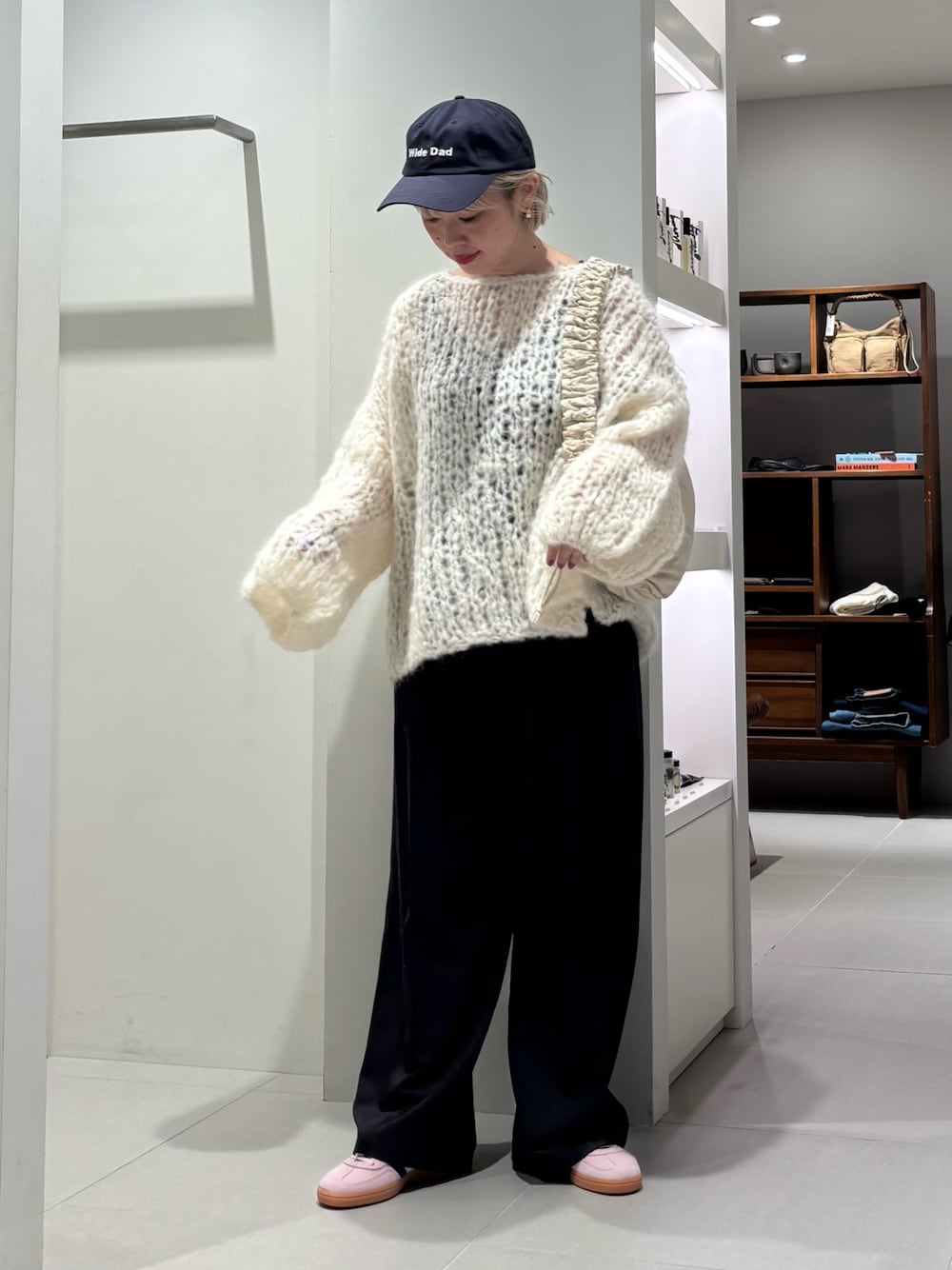 ホワイト系のニット/セーター、ホワイト系のショルダーバッグ、グレー系のその他パンツを着用したレディースの秋コーディネートの1枚目の写真