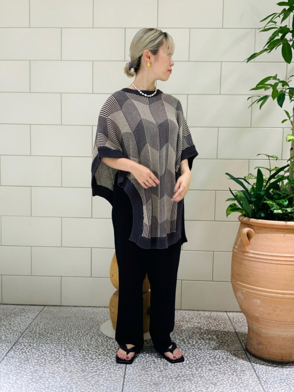 グレー系のニット/セーター、ブラック系のその他パンツ、ブラック系のサンダルを着用したレディースの夏コーディネートの1枚目の写真