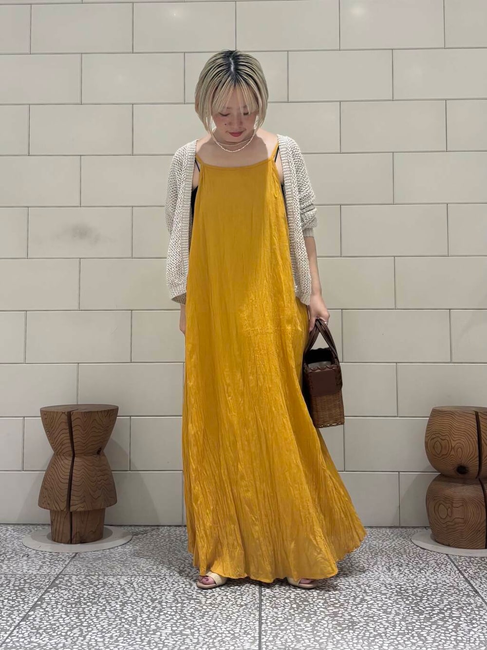 ホワイト系のカーディガン/ボレロ、ベージュ系のサンダル、イエロー系のワンピースを着用したレディースの春コーディネートの1枚目の写真