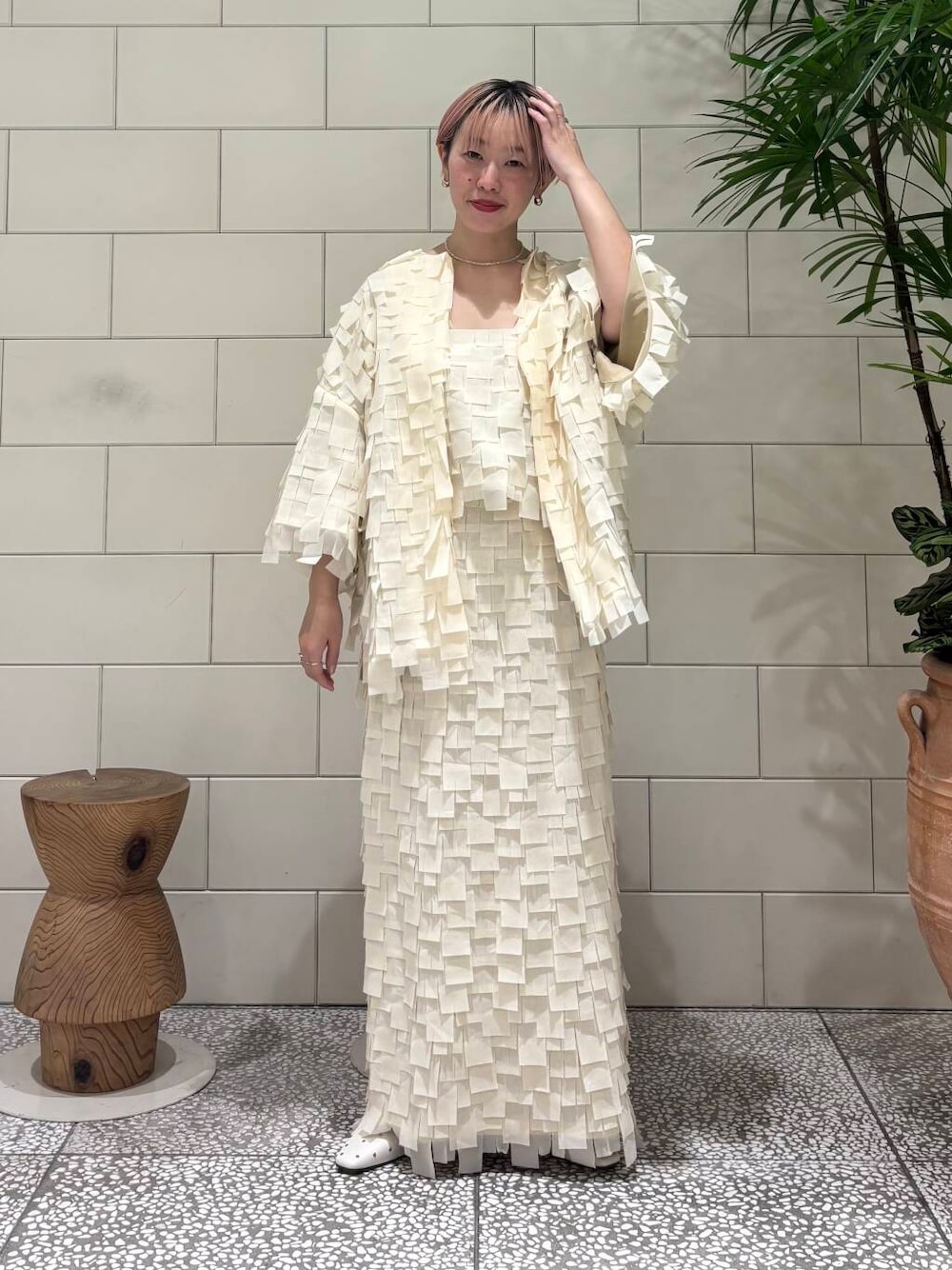 ホワイト系のパンプス、ホワイト系のテーラードジャケット、ベージュ系のスカートを着用したレディースの冬コーディネートの1枚目の写真