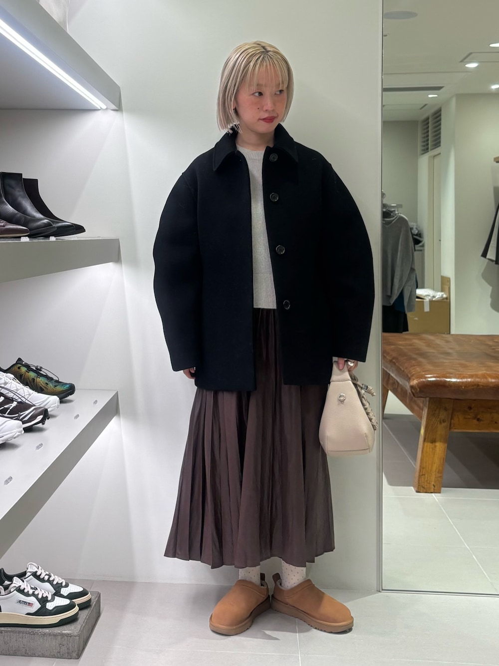 ブラック系のテーラードジャケット、グレー系のニット/セーター、ブラウン系のスカートを着用したレディースの秋コーディネートの1枚目の写真
