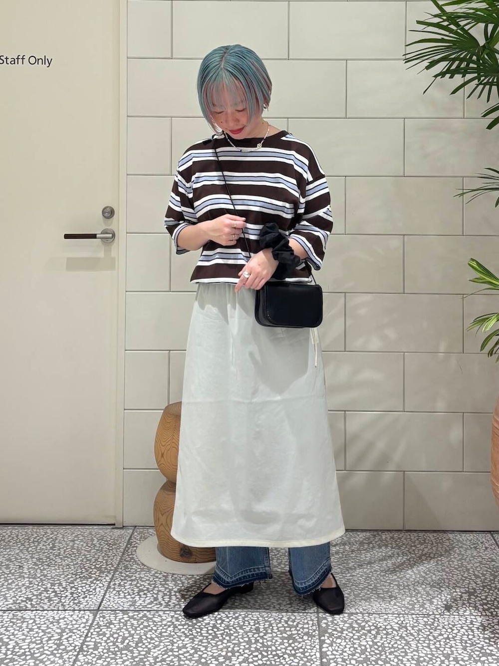 ブルー系のデニムパンツ、ブラック系のショルダーバッグ、ブラック系のパンプスを着用したレディースの春コーディネートの1枚目の写真