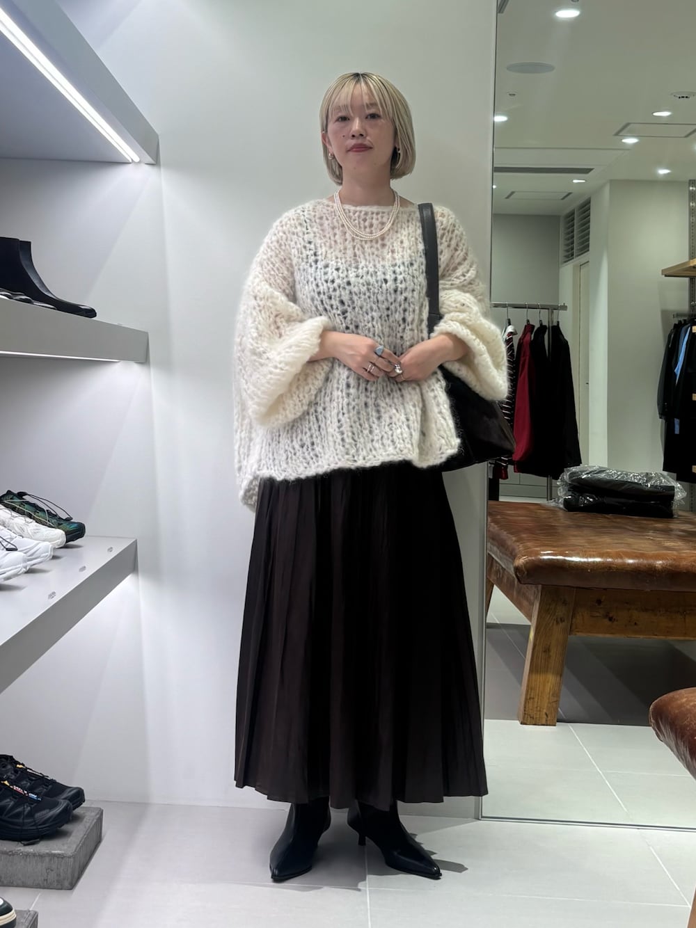 ホワイト系のニット/セーター、ブラウン系のトートバッグ、ブラウン系のスカートを着用したレディースの秋コーディネートの1枚目の写真