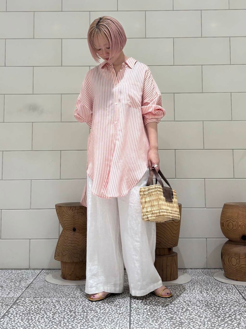 ブラウン系のかごバッグ、ホワイト系のその他パンツ、ゴールド系のサンダルを着用したレディースの春コーディネートの1枚目の写真