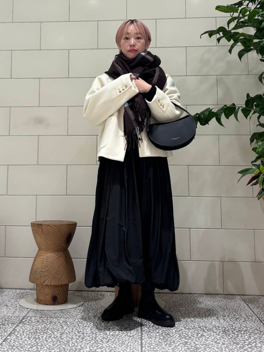 ブラック系のブーツ、ホワイト系のその他アウター、ブラック系のワンピースを着用したレディースの冬コーディネートの1枚目の写真