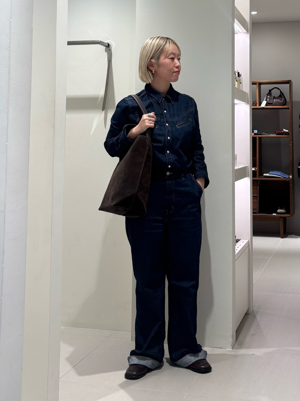 ブルー系のサロペット/オーバーオール、ブラウン系のトートバッグ、ブラウン系のローファーを着用したレディースの秋コーディネートの1枚目の写真