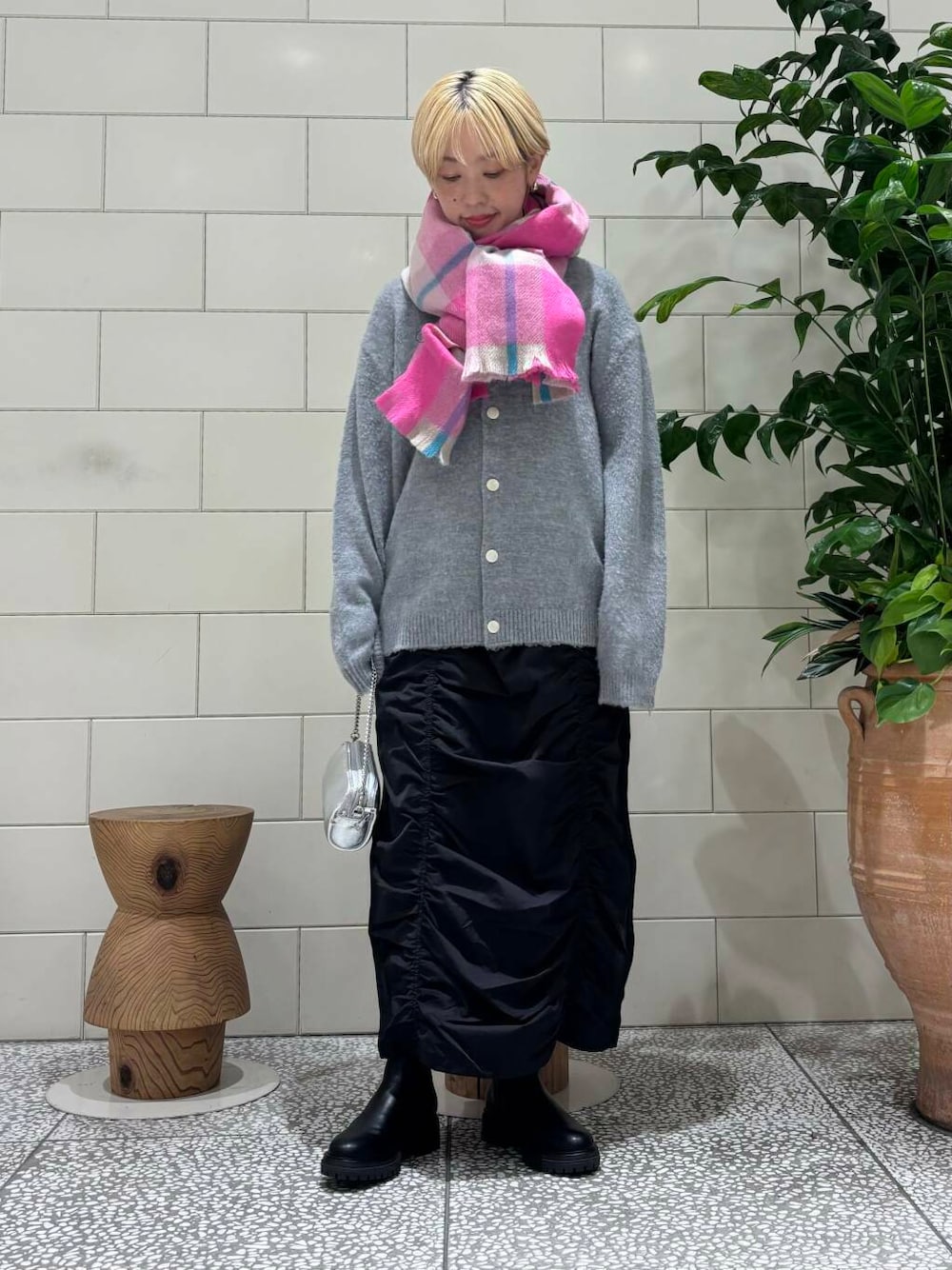 ブラック系のスカート、ブラック系のブーツ、グレー系のカーディガン/ボレロを着用したレディースの秋コーディネートの1枚目の写真