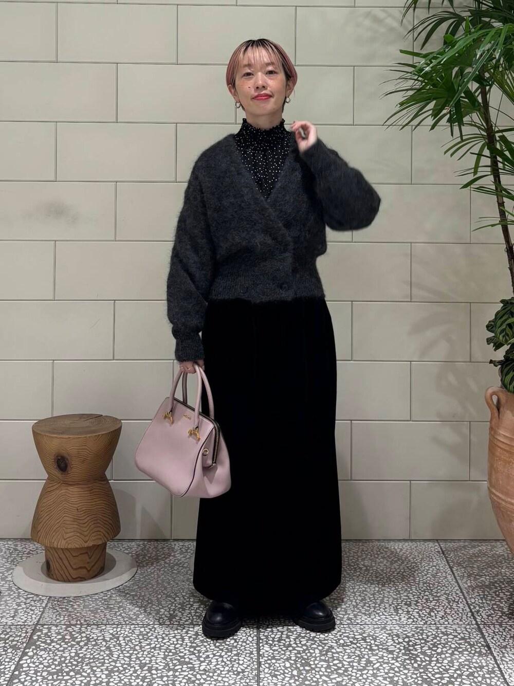 ブラック系のスカート、グレー系のカーディガン/ボレロ、ブラック系のシャツ/ブラウスを着用したレディースの冬コーディネートの1枚目の写真