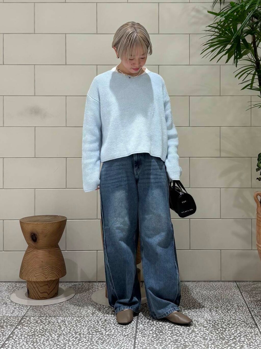 ブルー系のデニムパンツ、ブラック系のボストンバッグ、ブルー系のニット/セーターを着用したレディースの冬コーディネートの1枚目の写真