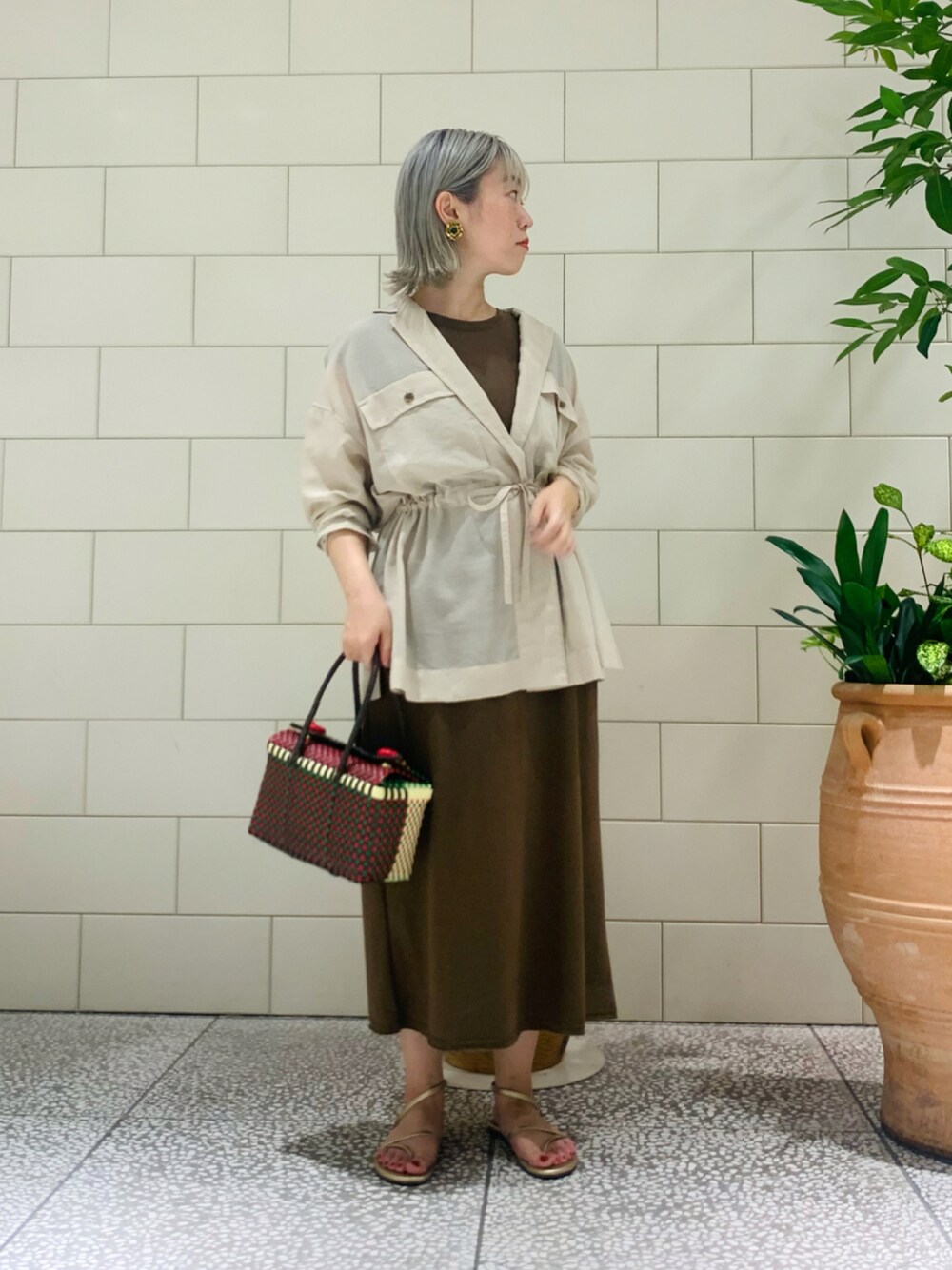 その他のバッグ、グリーン系のワンピース、ベージュ系のその他アウターを着用したレディースの夏コーディネートの1枚目の写真