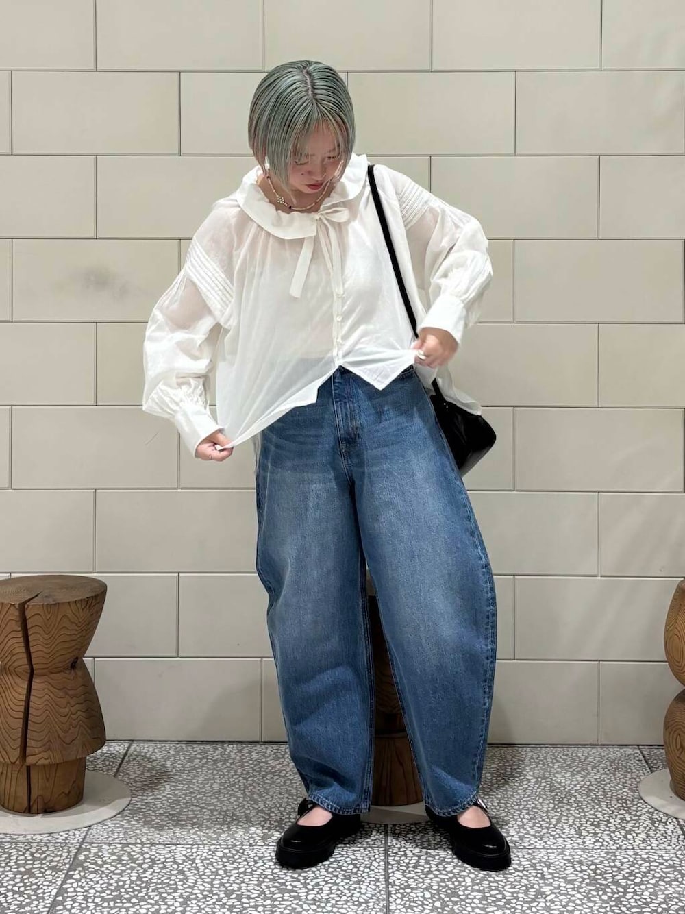 ブルー系のデニムパンツ、ブラック系のショルダーバッグ、ホワイト系のシャツ/ブラウスを着用したレディースの春コーディネートの1枚目の写真