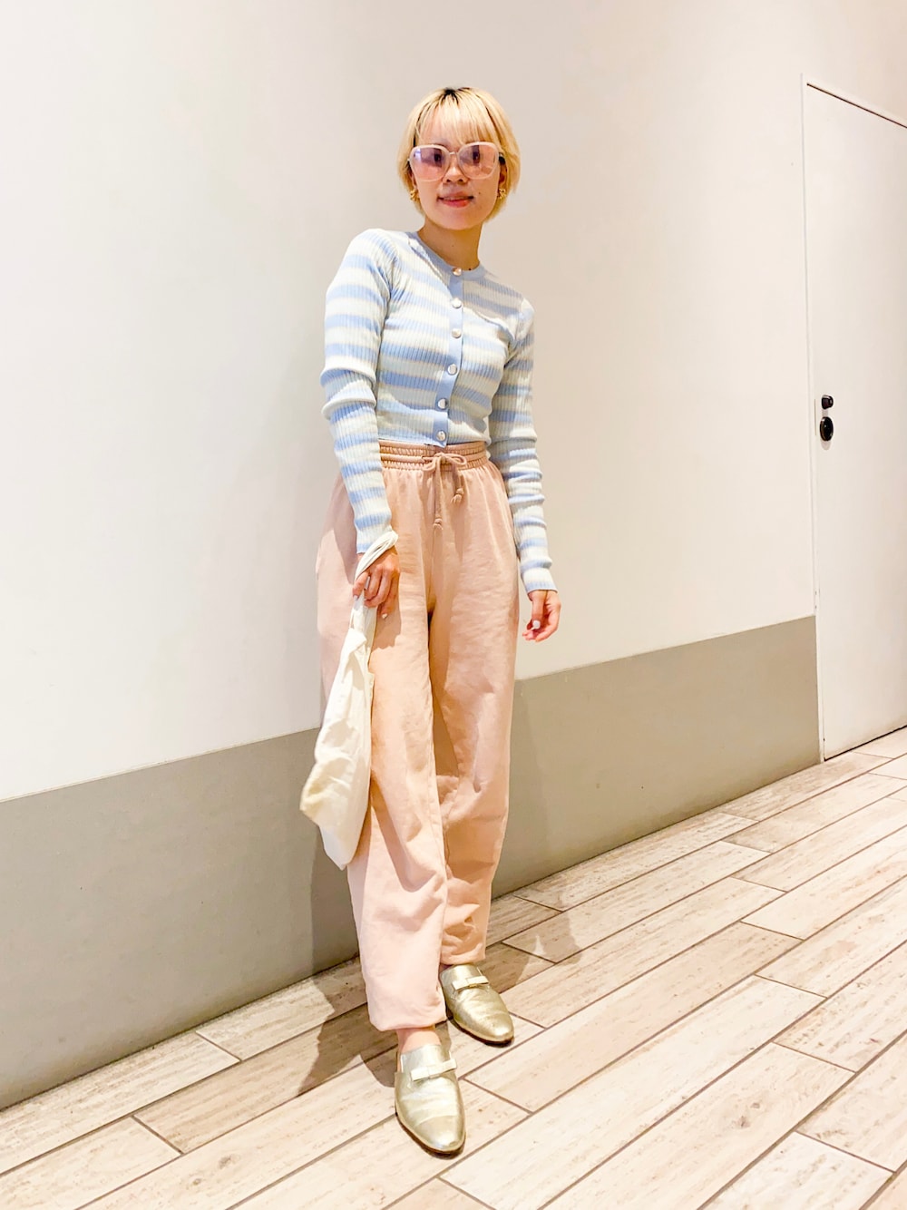 ベージュ系のその他パンツ、ブルー系のカーディガン/ボレロ、ゴールド系のその他シューズを着用したレディースの秋コーディネートの1枚目の写真
