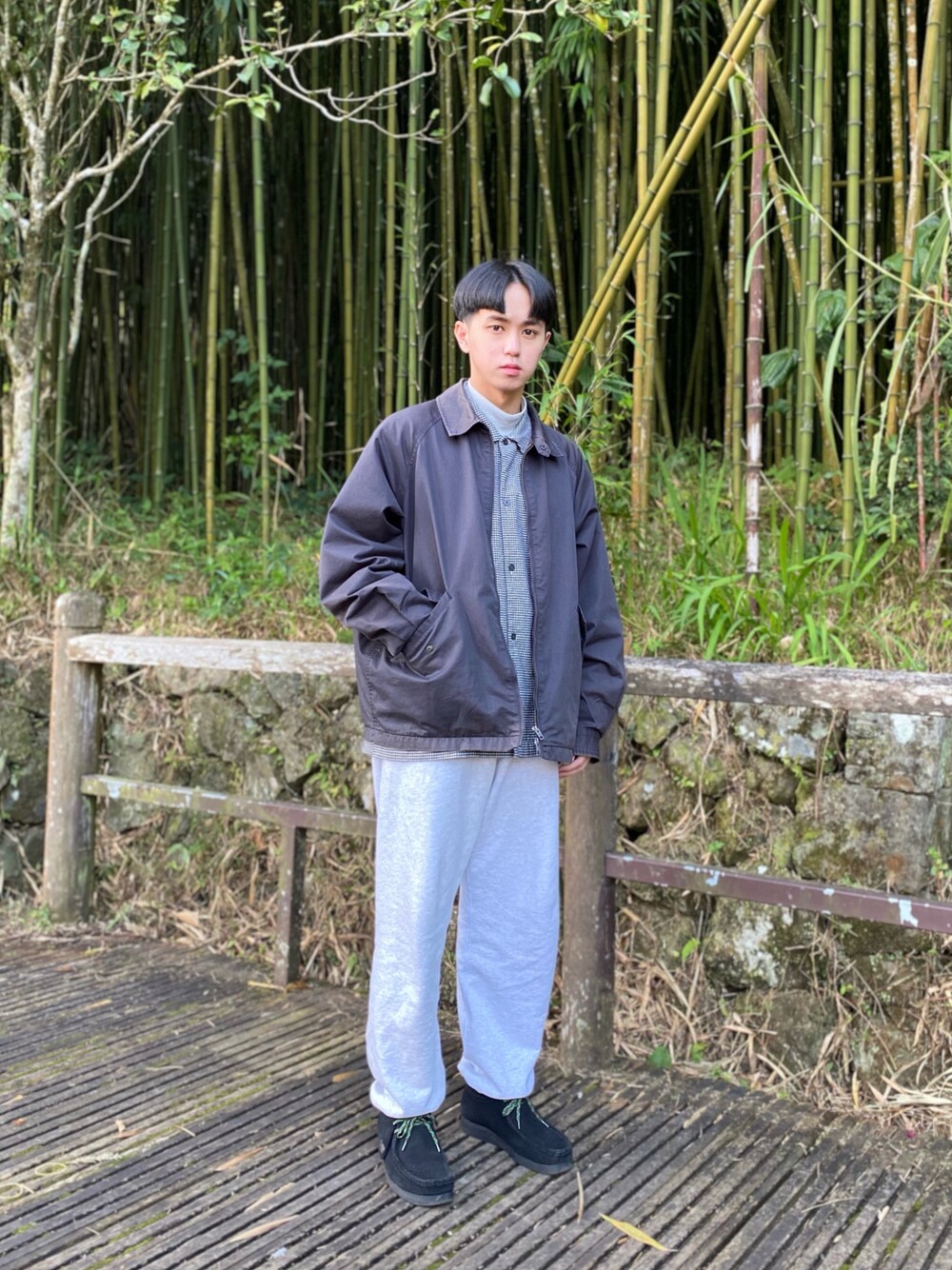 グレー系のブルゾン、グレー系のスウェットパンツ、ブラック系のモカシン/デッキシューズを着用したメンズの冬コーディネートの1枚目の写真