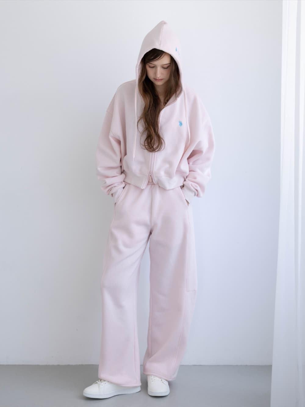 ピンク系のスニーカー、ピンク系のスウェットパンツ、ピンク系のパーカーを着用したレディースの秋コーディネートの1枚目の写真