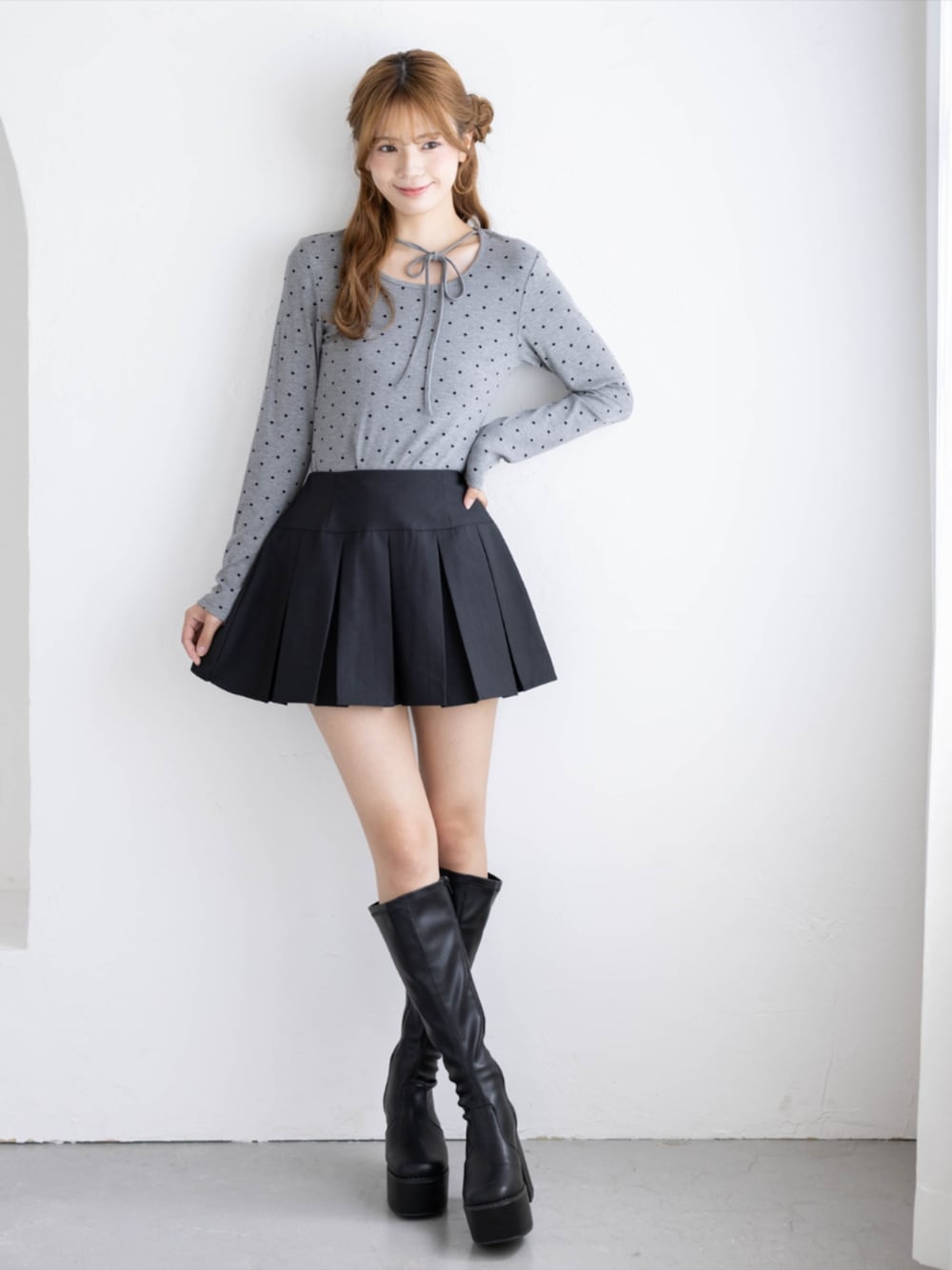 ブラック系のブーツ、ブラック系のスカート、グレー系のTシャツ/カットソーを着用したレディースの秋コーディネートの1枚目の写真