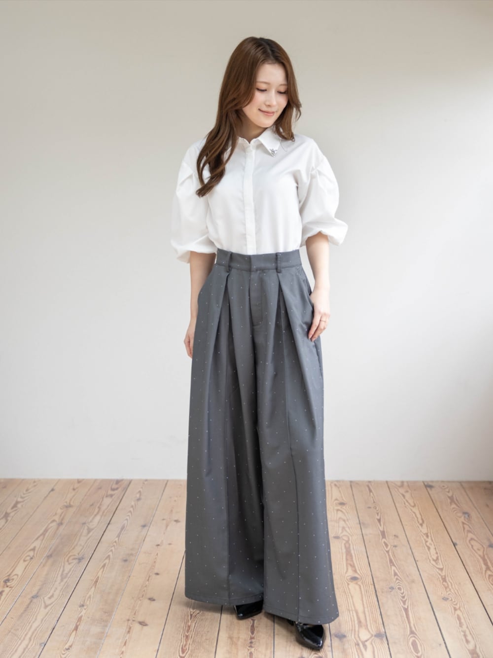 ブラック系のパンプス、グレー系のその他パンツ、ホワイト系のシャツ/ブラウスを着用したレディースの春コーディネートの1枚目の写真